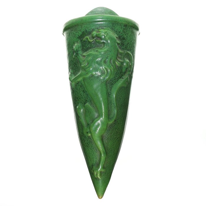 Strobl wall pocket, rampant lion, matte green, 15”: Strobl Pottery 15 inch wall pocket with the molded design of a rampant lion, covered in a mat green glaze. Marked on the back with the Strobl logo and “359”. There is no crazing with just a bit of