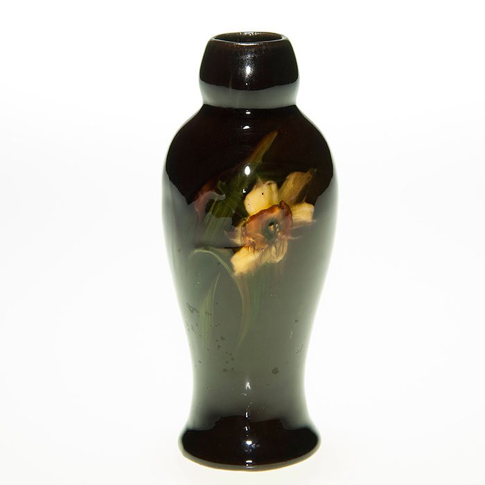 Roseville Hollywood Ware vase, 5 1/8”, rare label: Rozane vase in miniature decorated with daffodil and leaves and signed with the obscure marks of an artist. This 5 1/8 inch vase is accompanied by a rare serrated round label reading “Hollywood Ware