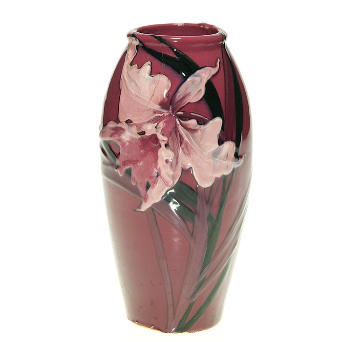 Weller Red Louwelsa, Orchids, 7”, incised marked: Rare Weller Red Louwelsa vase, dressed in glossy red glaze and beautifully decorated by Mae Timberlake arranging a pink orchid front and back with some foliage. Height 7 inches. Incised “Weller Pott