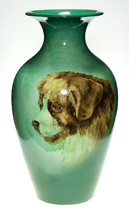 Weller Etched Ware vase, dog, Wilson, 27 3/8”: Rare Weller Etched Ware vase done by Albert “Doghead” Wilson. Pictured is a nearly life size head of a Saint Bernard, both etched into the body of the vase and slip painted by Wilson. Standing 27 