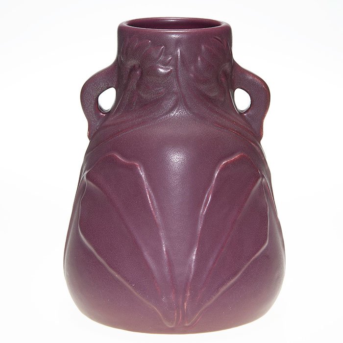 Van Briggle 2 handles vase, 1903, rose, 9 3/4”: Van Briggle twin handled 9 3/4 inch vase with embossed daisies, done in 1903 and covered with green over rose mat glazes. Incised on the bottom with the company logo, Van Briggle, 1903 and a roman num