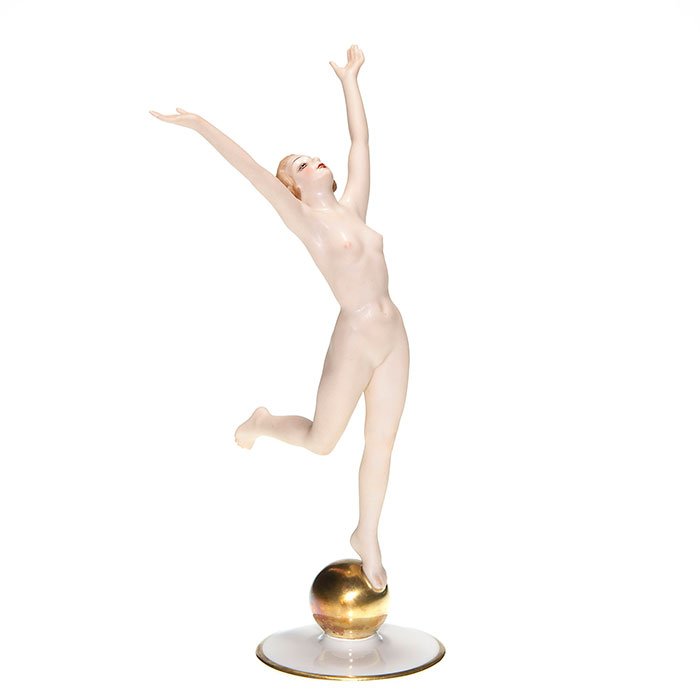 Hutchenreuther polychromed nude figure, 8 1/2”: Hutchenreuther polychrome nude figure balanced on a gold sphere. Height 8 1/2 inches. Incised “K. Tutter” under glaze. Green transfer “Hutchenreuther Gelb, LHS Lion, Bavaria Germany” logo. Exc