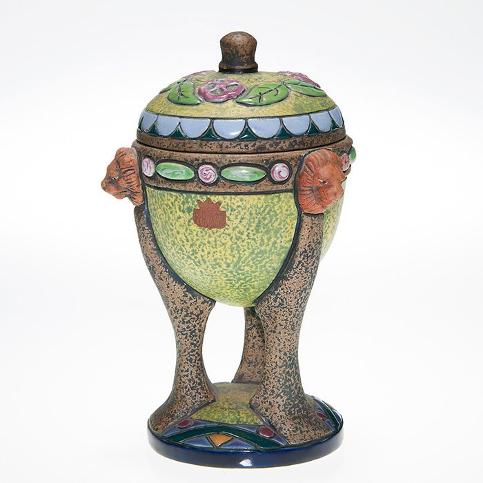 Czech Amphora covered urn, lion heads, 8 3/4”: Czech Amphora covered urn with lion heads at the top of the three legs. Marked with an “Amphora Made in Czecho-Slovakia” oval ink stamp logo. Height 8 3/4 inches. Excellent original condition.