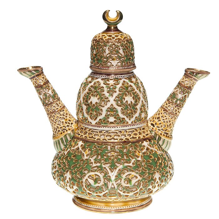 Zsolnay 2 spouted decanter, reticulated body & lid: Good Zsolnay double spouted decanter with reticulated body and cover. Height 11 inches. Marked with the 5 churches logo in gold. Repair to the cover’s insert and the rim of the container. Pictured i