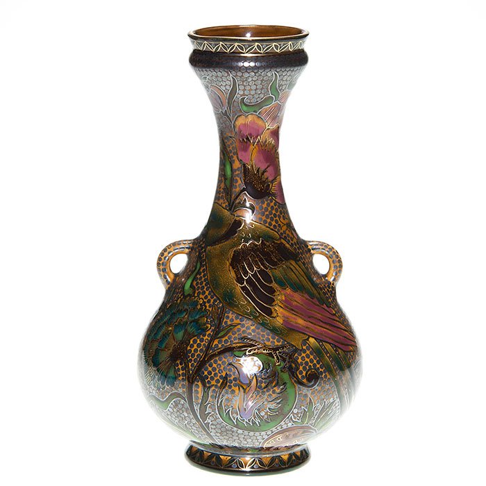 Early Zsolnay lusterware vase, birds, insects, 10 3/8”: Early Zsolnay lusterware handle vase with a peafowl on the ground and a bird in a flowering branch and insects buzzing about. Height 10 3/8 inches. Incised “702...10” beneath. Beautiful design wit