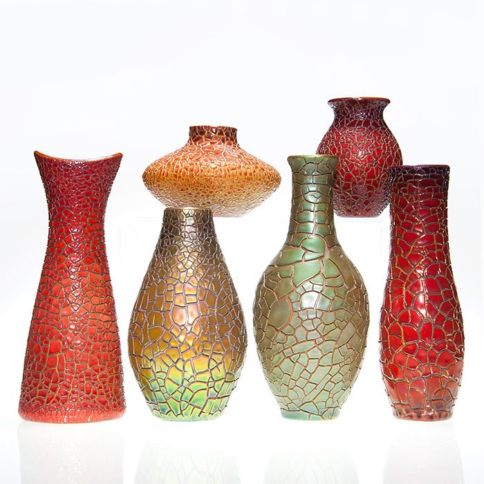 6 Zsolnay crackle ware vases, tallest 11 1/4”: Group of six Zsolnay vases, all having a crackled luster finish. There are three red luster vases in the following sizes: 5 1/8”, 10 1/2” and 11 1/4”. One 4 inch vase has a red and gold luster f