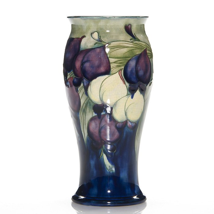 Moorcroft Wisteria vase, Burslem, 7 7/8”: Moorcroft Burslem vase with blue, cream and amethyst Wisteria design. Height 7 7/8 inches. Impressed marked “Moorcroft Burslem, England” plus the green slip signature for William Moorcroft. Excell