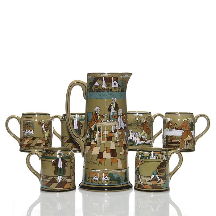 Buffalo Deldare tankard and 6 mugs, 12 1/4 + 4 1/4: Buffalo Deldare Pottery tankard with 6 mugs. The 12 1/4 tankard with entitlements are “The Great Controversy” and “All you have to do, teach the Dutchman English”, artist REX, excellent condit