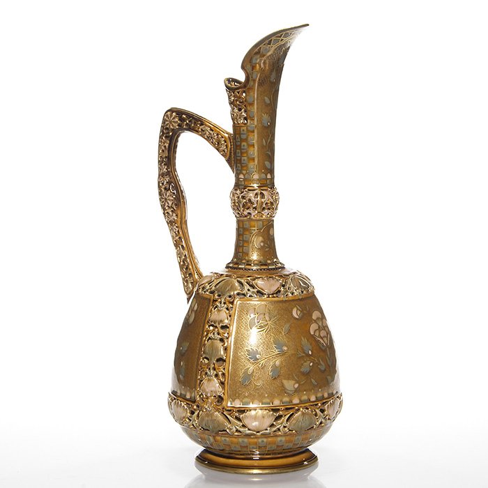 Zsolnay Pecs early ewer, gold, flowers, 16 1/2”: Early Zsolnay ewer with pierced & enameled flowers featured on the handle, rim, neck and as a border design. Panels showing raised floral & leaves are set against a busy gold scroll design and the app