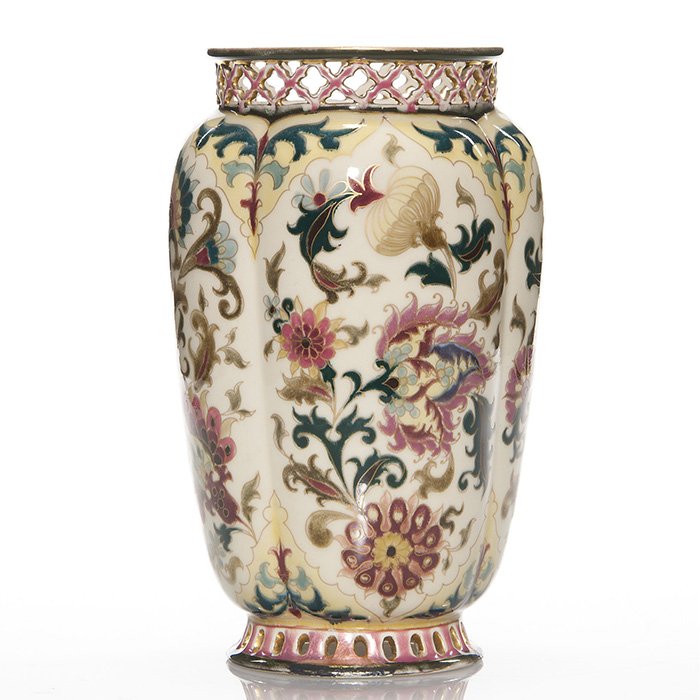 Zsolnay Pecs early floral vase, reticulated rims,9 3/8”: Good Zsolnay Pecs vase with reticulated rims, the melon ribbed body nicely decorated with an early Persian floral design set against antique white. Height 9 3/8 inches. Under glaze blue marks “Zsoln