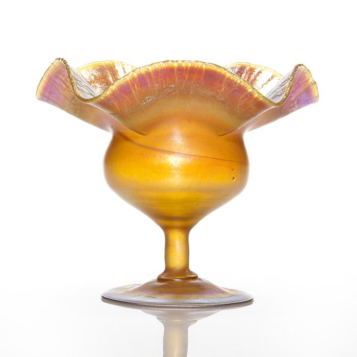 Mini Tiffany flower form vase, gold, 4 1/4”, signed: Miniature Tiffany flower form vase in iridescent gold with a flirty ruffled rim. Measures 4 1/4 inches by 5 inches across. Engraved “2259D, L.C.Tiffany-Favrile”. Silvery lilac tones to the interio