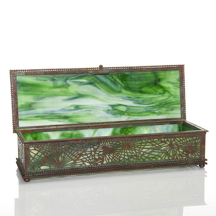 Large Tiffany glove box, Pine Needle, 3”X13 3/4”,: Sizable Tiffany glove box displaying the bronze Pine Needle decor over green slag glass, accented by beaded chains and lofted on four small bun feet. Measures 3 inches tall by 13 3/4 inches long and 4
