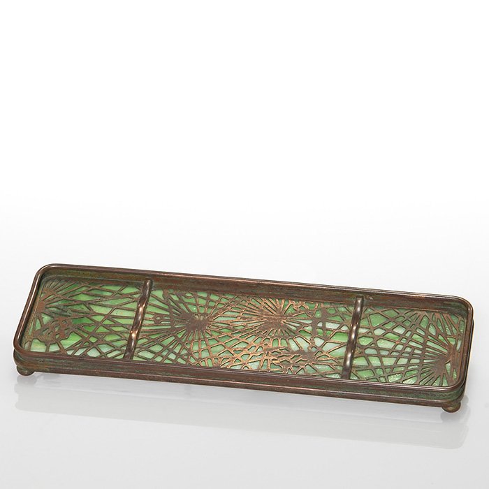 Tiffany pen tray, Pine Needle design, 9 5/8”L: Tiffany bronze pen tray with the Pine Needle pattern silhouetted over green slag glass and lofted on tiny bun feet. Measures 9 5/8” long by 2 3/4 inches wide. Impressed “Tiffany Studios, New York,