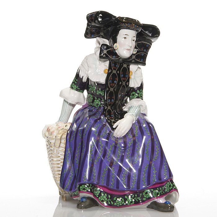 KPM Westphalian Buckeburgerian figure, 10": Uncommon KPM figure of a Westphalian Buckeburgerian, a woman in native dress sitting on a basket of apples. Designed by Karl Himmelstoss, this work is intricately painted with great detail and color.