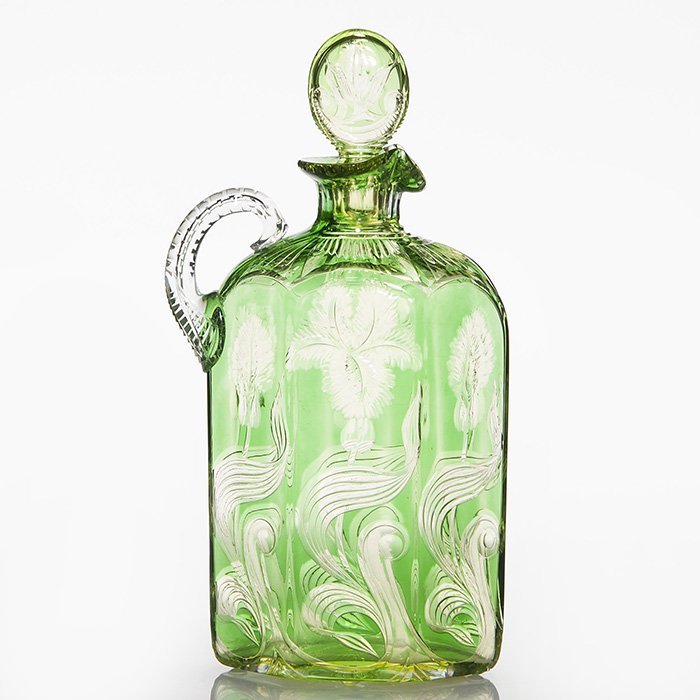 Nouveau engraved decanter, stopper, green,10 1/2”: Good Art Nouveau six sided green and chartreuse decanter skillfully wheel cut to clear with iris and buds among reed leaf blades. The shoulder is enhanced with ray cuttings, the neck with fluting and 