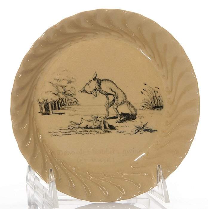 Rookwood Uncle Remus dish, Cranch, 1888, 6 3/8”: Rookwood dish decorated with an Uncle Remus tale, the work of Edward P. Cranch in 1888. The decoration shows Brer Fox menacingly standing over a prone Brer Rabbit with the notation “Dese yer Rabbits