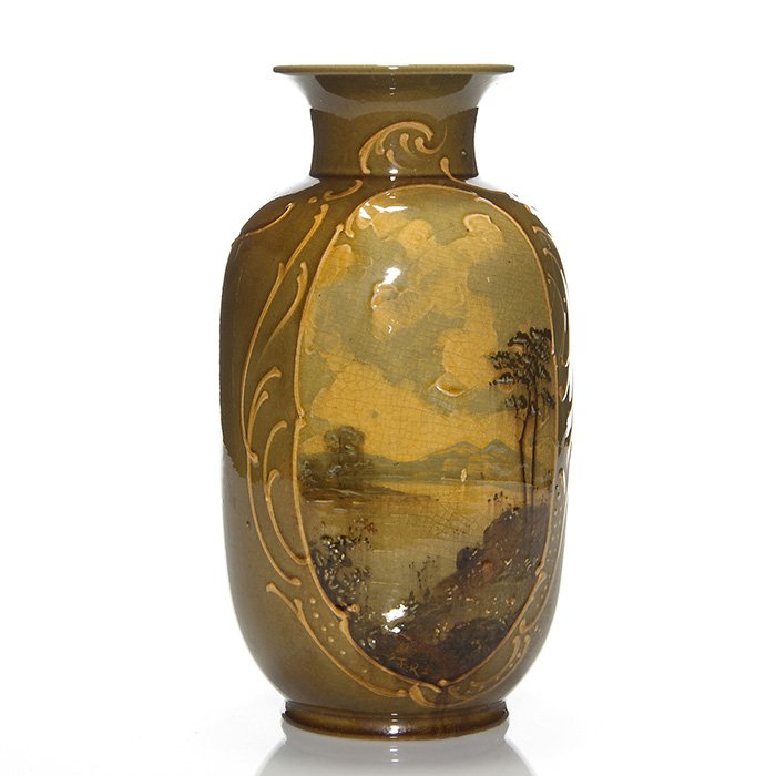 Wardle Pottery scenic vase, F.H. Rhead, 10 1/8”: Wardle Pottery scenic vase painted in heavy slip by Frederick Hurten Rhead. Pictured in an oval panel is an expansive cloudy sky, a quiet lake, a far away sail boat and several trees on the shore. Sli