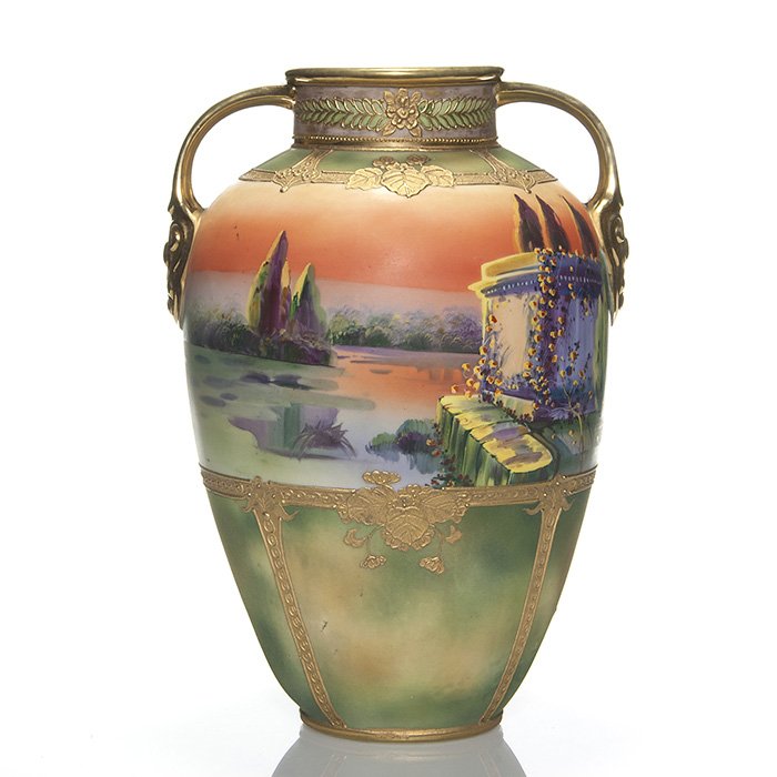Large Nippon scenic handled vase, 13 1/8”: Monumental handled vase displaying a continuous scene of a tree lined lake, a large monument and birds flying across a bright orange sky. The neck, shoulder and lower body has decorative relief design