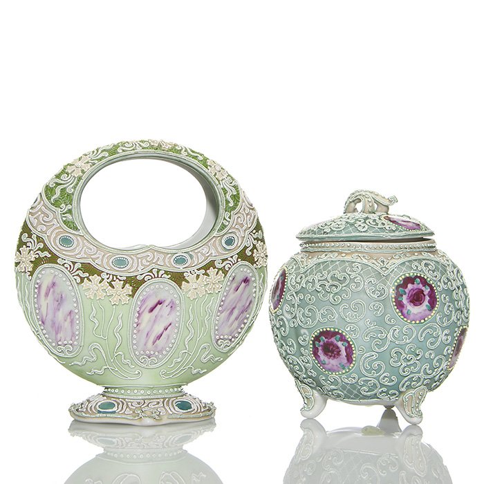 2 Nippon Moriage: covered cracker jar + basket: Two Nippon Moriage. 1) Tri-footed cracker jar with lid, hand painted with ruby roses, measuring 7 1/2 inches by 6 1/2 inches across. Black stamped with square & character marks beneath. Missing raised