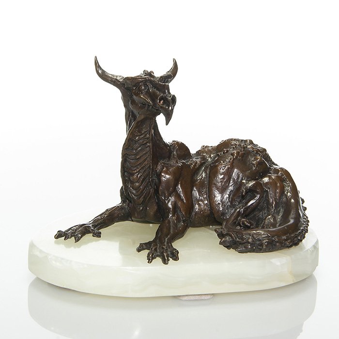 James Herrmann bronze Resting Dragon, 5 1/4”: Figural bronze by James Herrmann of a mythical horned dragon resting peacefully upon his custom white onyx base hand carved by Mr. Herrmann. Measures 5 1/4 inches by 7 1/2 inches across. The bronze is