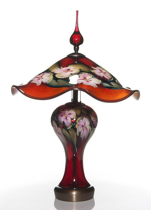 C. Lotton Multi Flora lamp, Selenium red, 28”, 1993: Impressive Charles Lotton Selenium Red Multi Flora lamp. The shade, 19 inches in diameter, displays a dozen pink ruby flowers amid variegated blue green foliage. The shapely base reveals eight blossom
