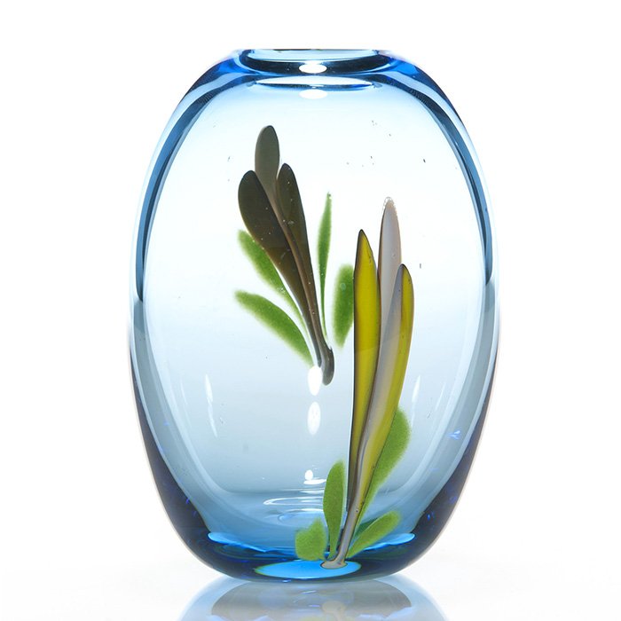 Labino vase, blue, leaves, 5 7/8”, signed, 1980: Dominick Labino clear blue vase displaying a yellow & white flower bud with green foliage on the front and back. Measures 5 7/8 inches. Engraved “Labino, 1-1980” within the polished pontil. Stray 