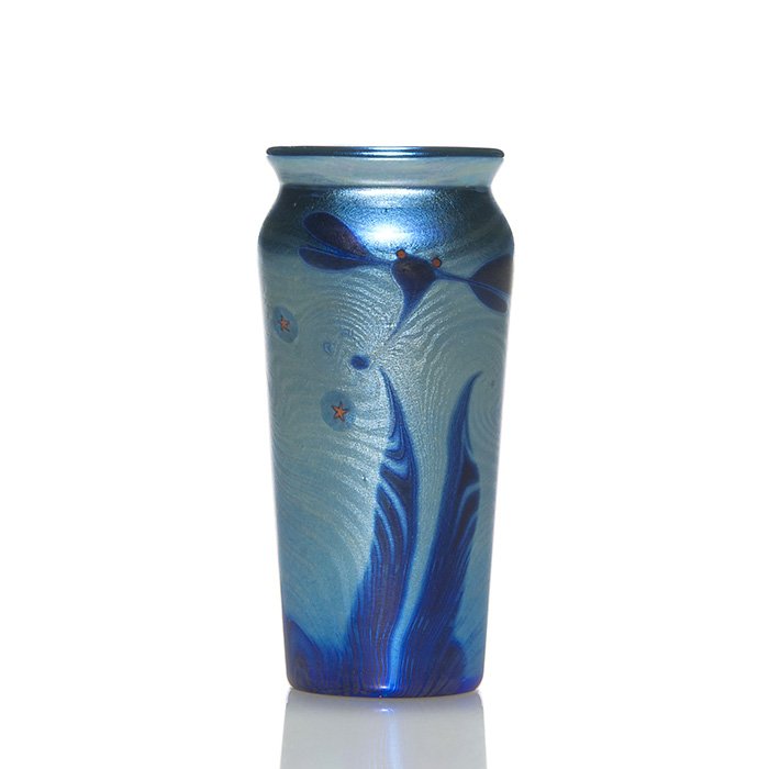 Lundberg mini vase, dragonflies, stars, 3 1/4”, 1976: Early Lundberg Studios miniature aurene blue vase with a night scene featuring red eyed dragonflies hovering before a silvery “King Tut” watery backdrop, a scatter of orange stars reflect upon the