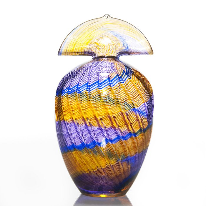 Buzz Blodgett fan top vase, basket weave, 10 1/4”: Buzz Blodgett “Tsarina Series” fan top vase and a basket weave design done in a pleasing amber and purple. Measures 10 1/4 inches by 6 1/2 inches across. Engraved by the artist with 2002 date and 