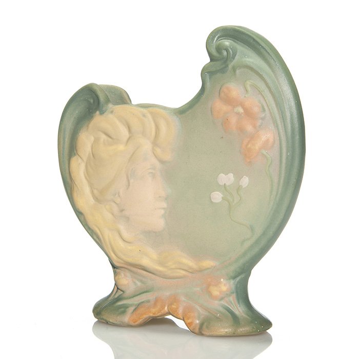 Weller Art Nouveau Shell vase, 7 3/8”: Weller Art Nouveau 7 3/8 inch shell vase with the visage of maiden on the front and back a nautilus shell design. Impressed WELLER in small block letters on the bottom. There are areas of crazing and