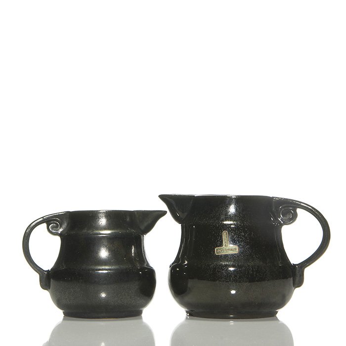 2 Fulper pitchers in Mirror Black 5 3/8” & 4 3/4”: Fulper Pottery 5 3/8 inch pitcher covered in the Mirror Black glaze. Marked with the Fulper racetrack ink stamp and having an original inverted “T” shaped “Fulper Pottery” label affixed to the
