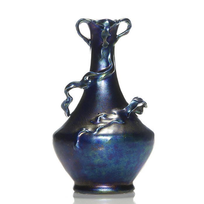Iridescent Hungarian Helioscene vase, 8 1/2”: Iridescent Hungarian Helioscene porcelain vase with vines writhing the body and tendrils cascading the rim. Height 8 1/2 inches. Tiny nick to a tendril and glaze pulls at the base. Handsome smooth iri