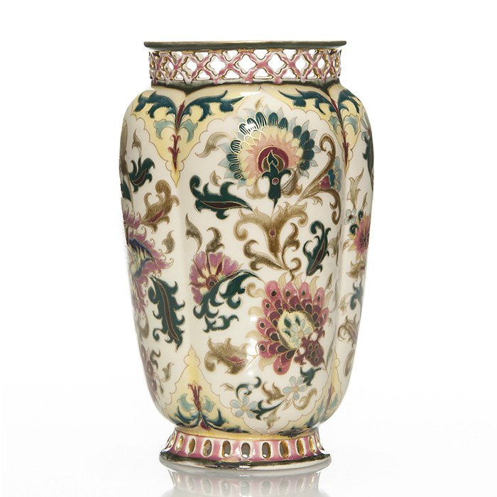 Zsolnay Pecs early floral vase,reticulated rims, 9 3/8”: Good Zsolnay Pecs vase with reticulated rims, the melon ribbed body nicely decorated with an early Persian floral design set against antique white. Height 9 3/8 inches. Under glaze blue marks “Zsoln
