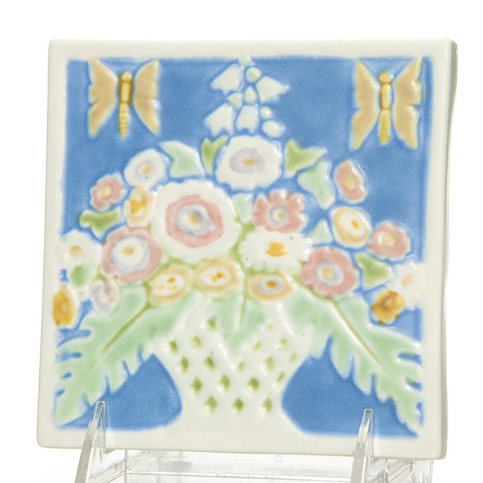 Rookwood “Flower Basket” trivet, 1944, 5 5/8”: Rookwood flower basket trivet with butterflies done in Vellum glazes in 1944. Marks include the Rookwood logo, date and shape 3206. Size is 5 5/8 inches square. Uncrazed and in excellent original cond