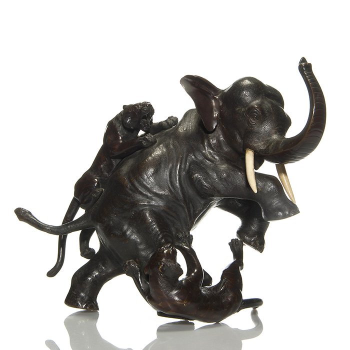 Japanese bronze elephant with tigers, 14” by 17 1/2”: Large Japanese bronze figural of an elephant being attacked by two tigers. Height 14 inches and 17 1/2 inches tail to trunk. Artist signed on the pachyderms belly. Tiny non disfiguring nick to one tus