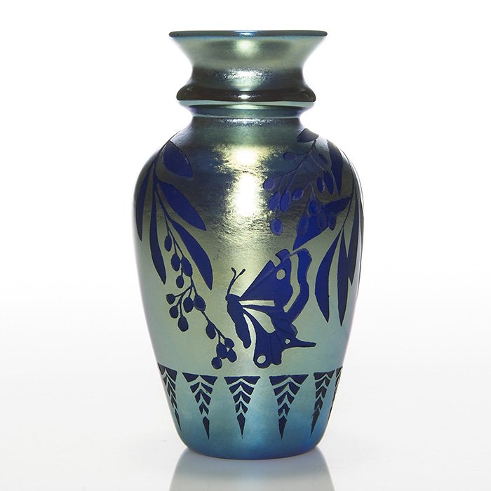 Orient & Flume cameo vase, blue, 7 1/2”, S. Hopper: Early Orient & Flume cameo vase created in 1978 by Shari Moayson Hopper entitled “Spring”. A large butterfly visits a branch of berries and leaves surrounding the aurene blue surface with the addi