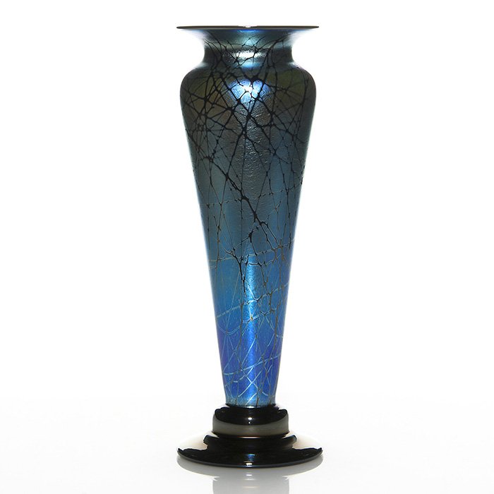 S. Abelman aurene blue-ebony vase, 13 1/4”, 2002: Handsome Stuart Abelman vase in aurene blue and ebony. The tapered body is decorative with an attractive web design and is steadied by a mirror black step base that reflects a golden hue. Mirror black