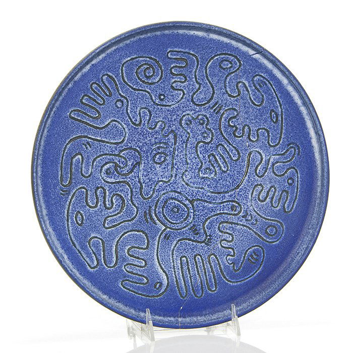 Scheier charger, faces, 1990, 12 3/4": Edwin and Mary Scheier charger with incised abstract faces covered in a purple mat glaze created in 1990. Incised on the bottom Scheier and 90. This piece cracked during firing and was glued back toge