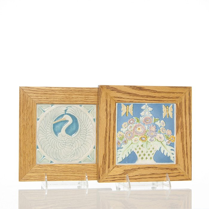 2 Rookwood 6" trivets framed, 1922, 1925: Two 5 1/2 inch square Rookwood tiles in newer custom frames measuring 8 3/8 inches. 1) 1922 shape 2047 with a crane. There is minor peppering and some tiny open glaze bubbles. 2) 1925 shape 3206 with