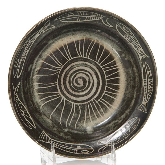 Ball and Bohrod plate, fish, sun, 9", signed: Carlton Ball and Aaron Bohrod pottery plate, displaying a parade of barracuda-like fish (a speciality of Bohrod) on the border with a rayed sun in the center and covered with a nice graphite black gla