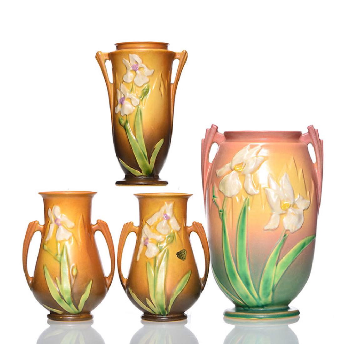 4 Roseville Iris vases, pink, brown, 924, 919, 2-916: Four Roseville Iris vases. 1) 9 1/4 inch Pink, shape 924-9, impressed marks, bad repair to base chip, crazed. 2) 7 1/4 inch brown, shape 919-7, impressed marks, interior mineral deposits. 3) Pair 6 1/
