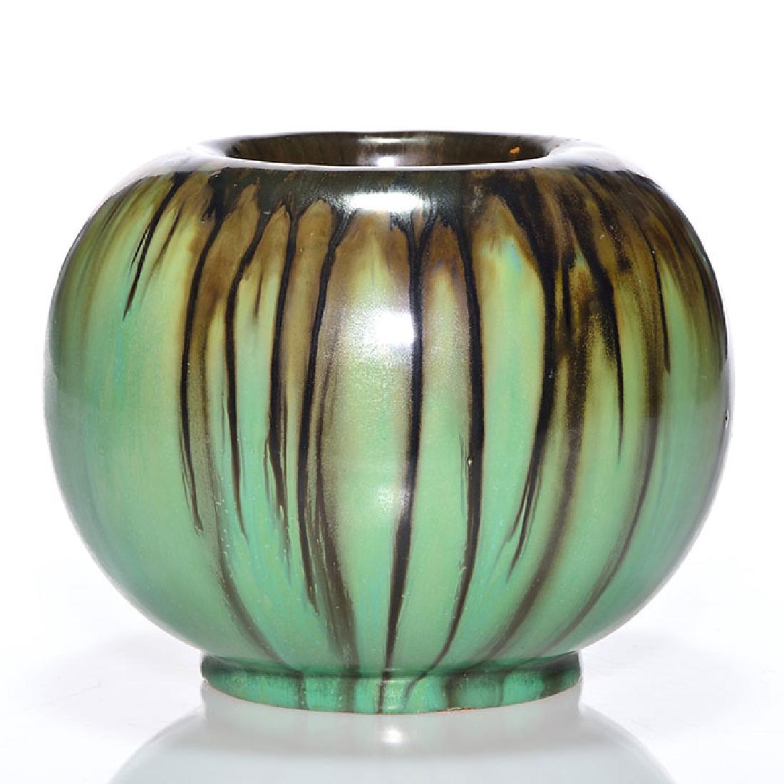 Fulper round vase, black and green, 5 3/4 inches: Fulper round vase covered with a green glaze having black dripped from the rim. Marked on the bottom with the rectangular Fulper ink stamp. There are a few tiny open glaze bubbles, a small blister and
