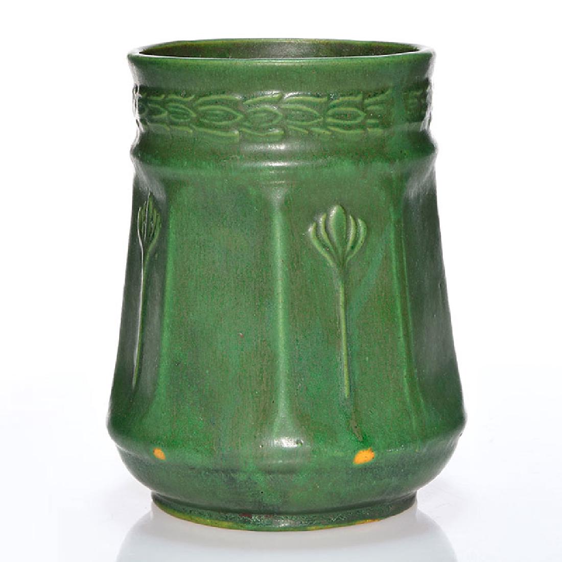 Green matt vase, floral pattern at rim, 7 inches: Vase with molded floral design covered in a rich mat green glaze with good charcoaling. Unmarked. There are a couple of glaze skips and a few minor glaze nicks. Height is 7 inches.