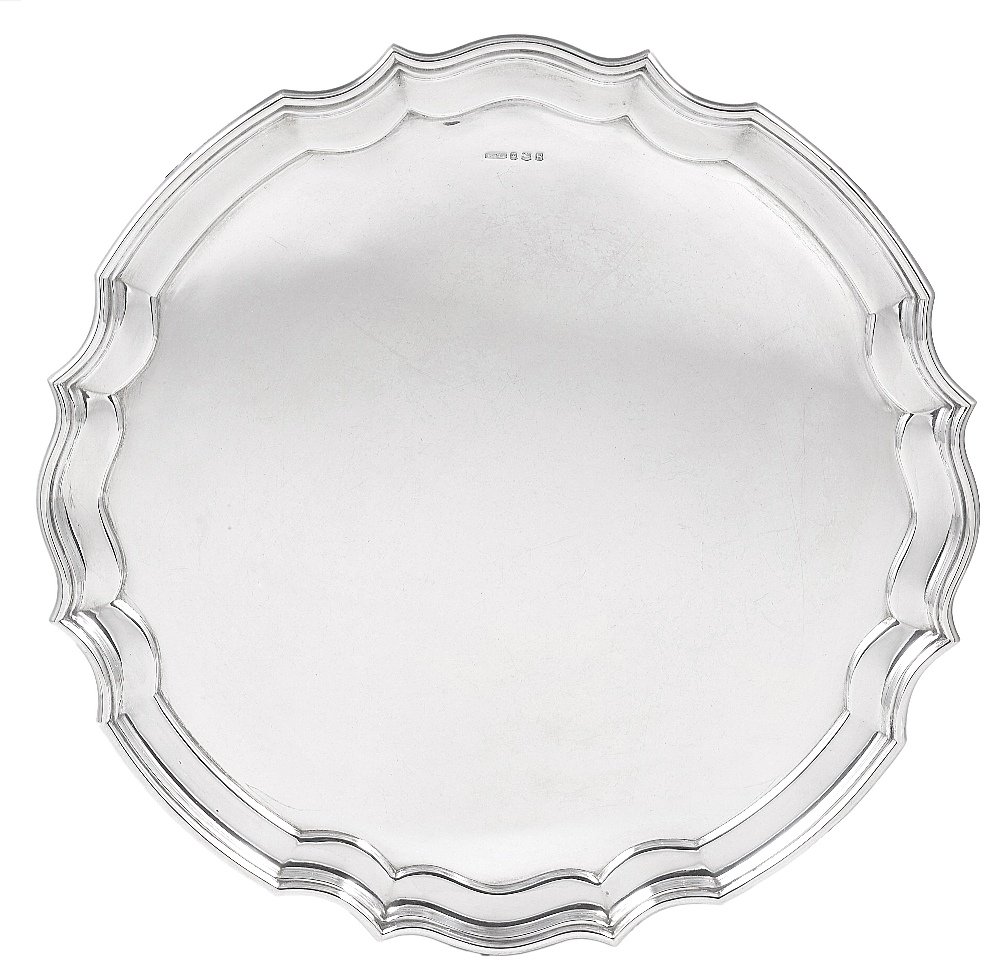 A SILVER SALVER, JOHN TURTON & CO., SHEFFIELD, 1959: A SILVER SALVER, JOHN TURTON & CO., SHEFFIELD, 1959 plain except for the moulded shaped rim, on four volute feet 36cm diameter, 1203gr (38oz)