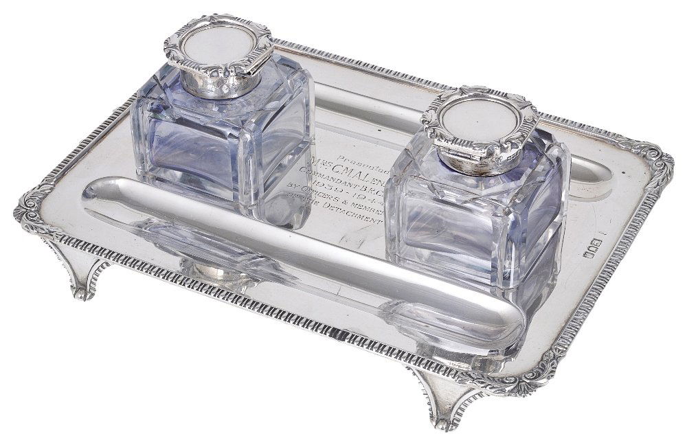AN EDWARD VII SILVER INKSTAND, CHARLES STUART HARRIS,: AN EDWARD VII SILVER INKSTAND, CHARLES STUART HARRIS, LONDON, 1905, RETAILED BY THE BRISTOL GOLDSMITHS' ALLIANCE rectangular, applied gadroon border above four panel supports, engraved with an inscrip