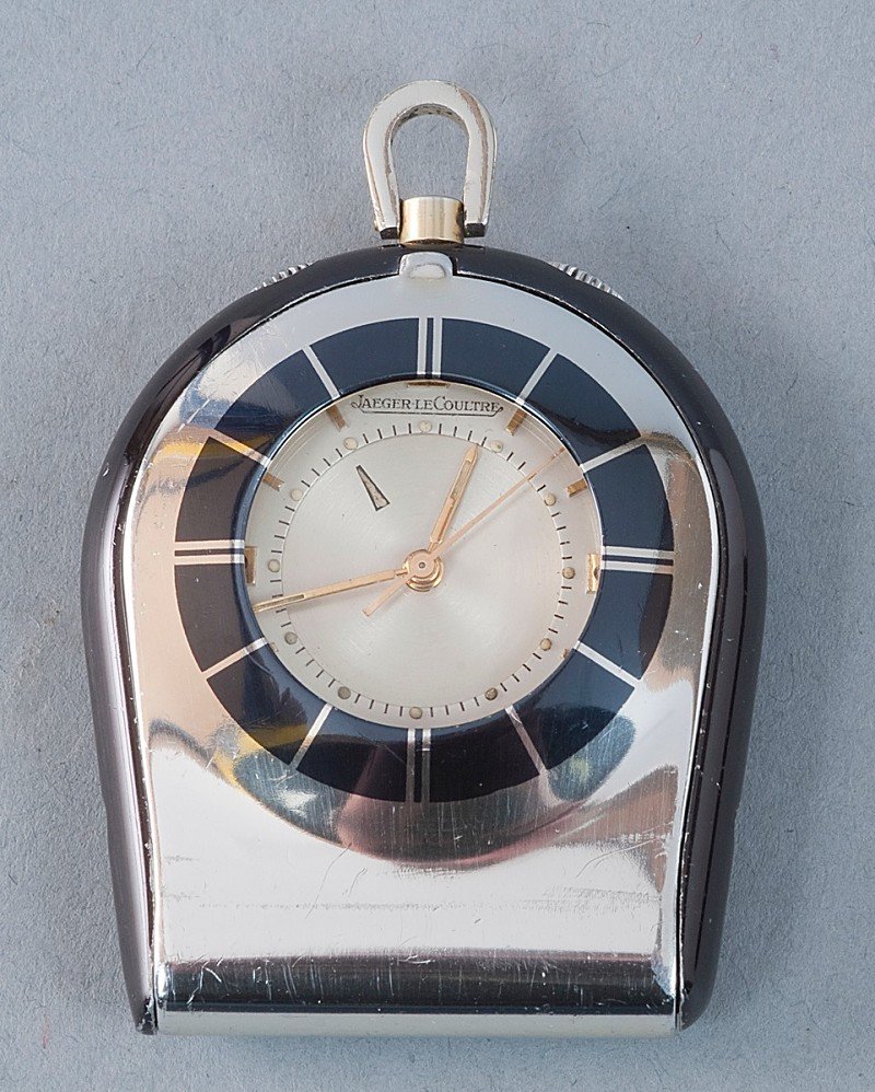 Jaeger LeCoultre Memovox, pocket or desk clock. Sw: Jaeger LeCoultre Memovox, pocket or desk clock. Switzerland about 1970, Factory No.: 1848552, Cal. 814 Case: Rhodium Plated 44.0 x 37.0 mm and painted metal housing, partly. Gilding rubbed. Hinged fro