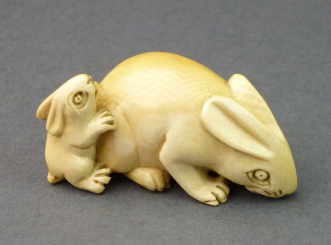 Netsuke, Hase mit Jungen, Mammutelfenbein, einseitig: Netsuke, Hase mit Jungen, Mammutelfenbein, einseitig Patina, bodenseitig signiert, Doppelbohrung, gut erhalten, H= 2,4cm, L= 3,8cm