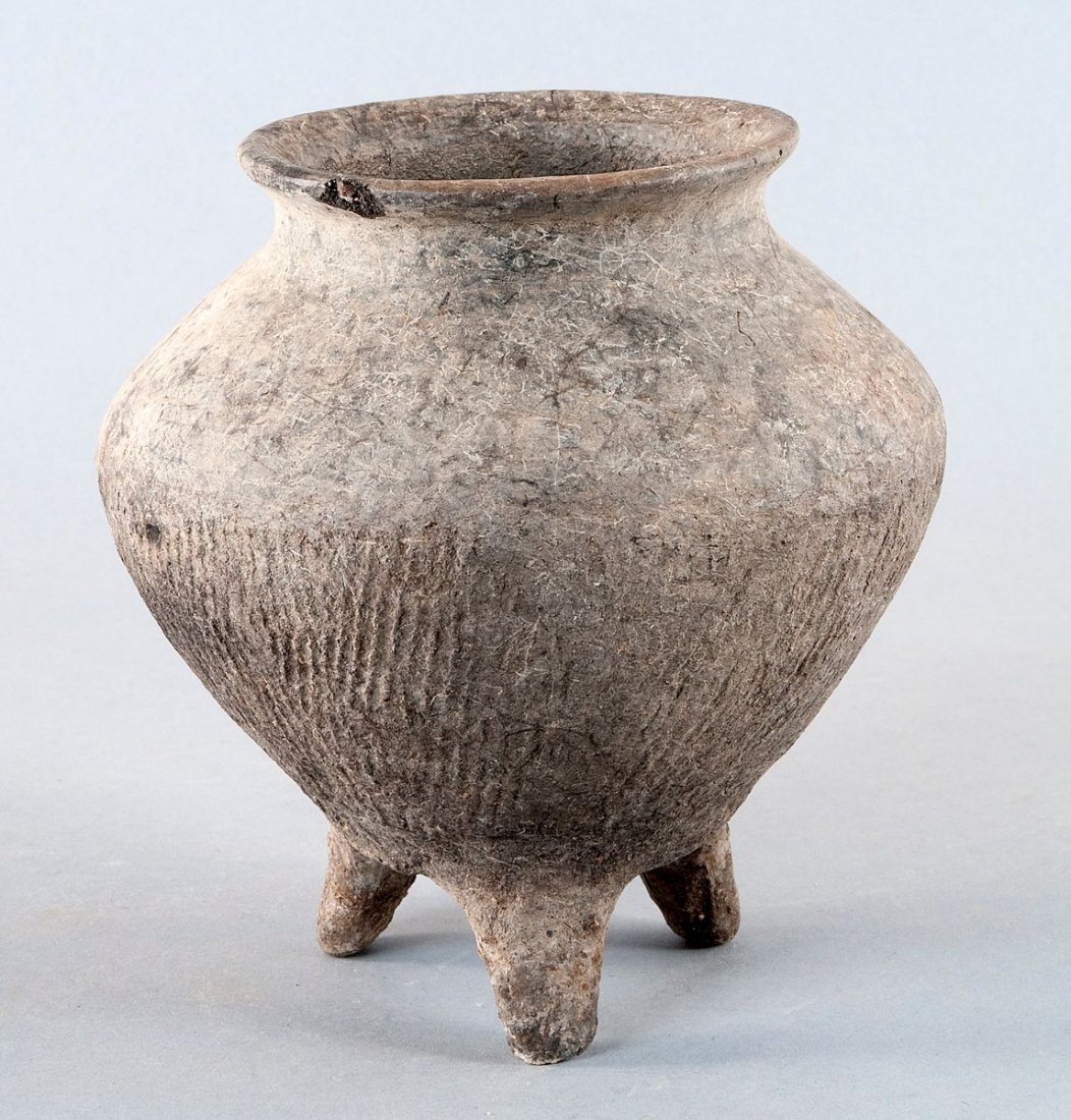 Neolithic Tripod vessel; Xiajiadian Culture: Neolithic Tripod vessel; Xiajiadian Culture, China, Inner Mongolia (ca. 2300-1600 BC.). Black and gray earthenware down tapered container based on three legs. The outer walling is in the lower part fi
