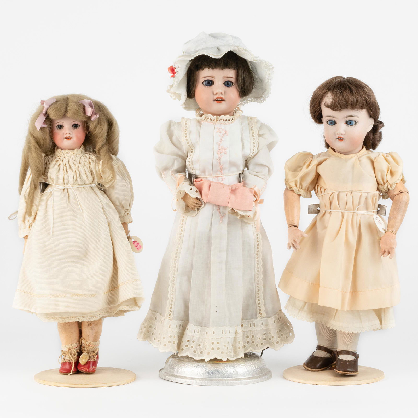 Varied lot of three bisque dolls. Consisting of: 1. Doll. SFBJ. Hands in good condition. Old clothin: Description ENVaried lot of three bisque dolls. Consisting of: 1. Doll. SFBJ. Hands in good condition. Old clothing with undergarments and old shoes. H.: 36 cm 2. Doll. Kraus Brothers. Marked 'C 165 K