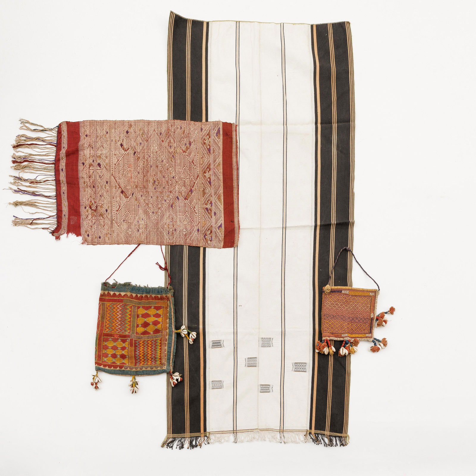 Varied lot of four pieces of textile with various origins. Two pouches decorated with cowries and tw: Description ENVaried lot of four pieces of textile with various origins. Two pouches decorated with cowries and two pieces of woven textiles with fringes.Beschrijving NLGevarieerd lot textiel. Met div