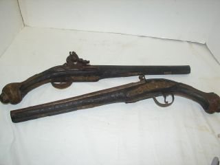 Pair of Flintlock Pistols Circa 1820-1840: Each pistol is highly decorated with wood stock inlaid with silver wire, heavily carved, mounts of ornate brass, hallmarked with makers mark and name (unclear). One pistol has damage on but small piec